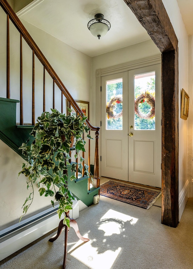 carpeted entrance foyer featuring french doors