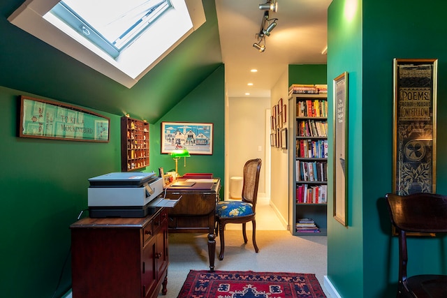 office with rail lighting, lofted ceiling with skylight, and carpet