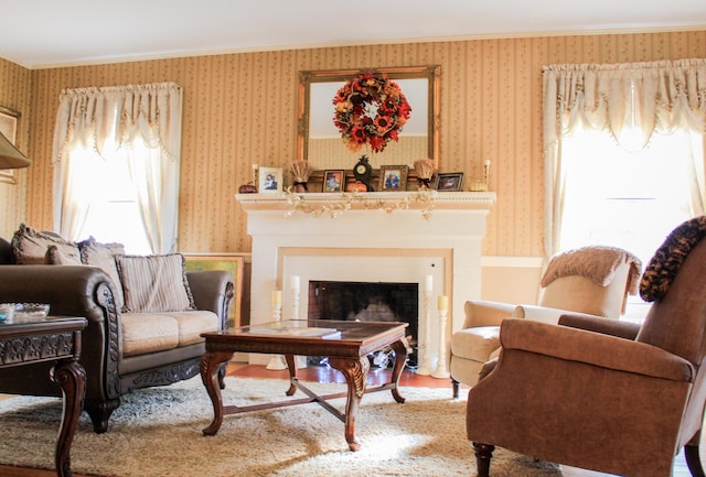 sitting room with hardwood / wood-style floors and crown molding