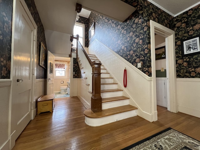 stairs featuring ornamental molding and wood-type flooring