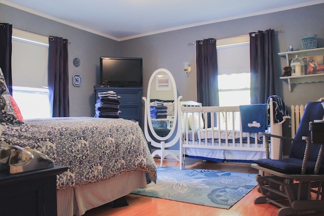 bedroom with crown molding and hardwood / wood-style floors