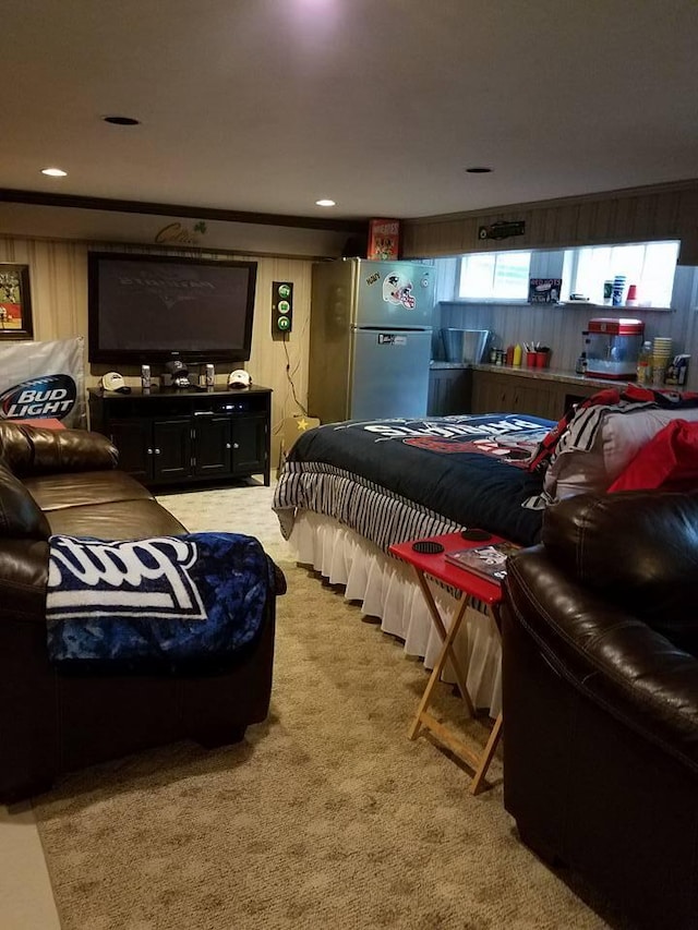 carpeted bedroom featuring wooden walls and stainless steel fridge