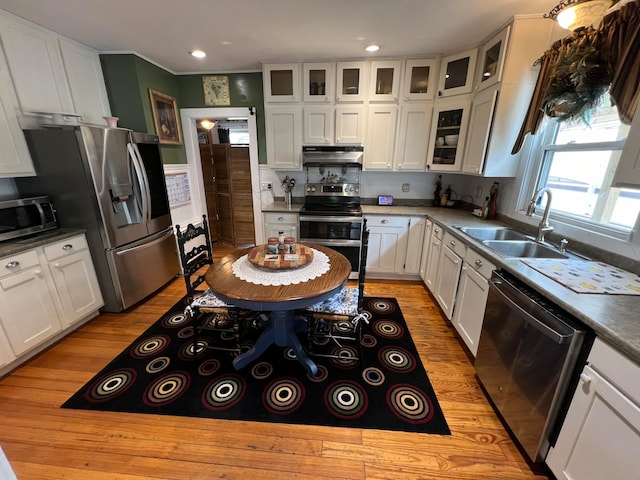 kitchen featuring stainless steel appliances, white cabinetry, sink, and light hardwood / wood-style flooring