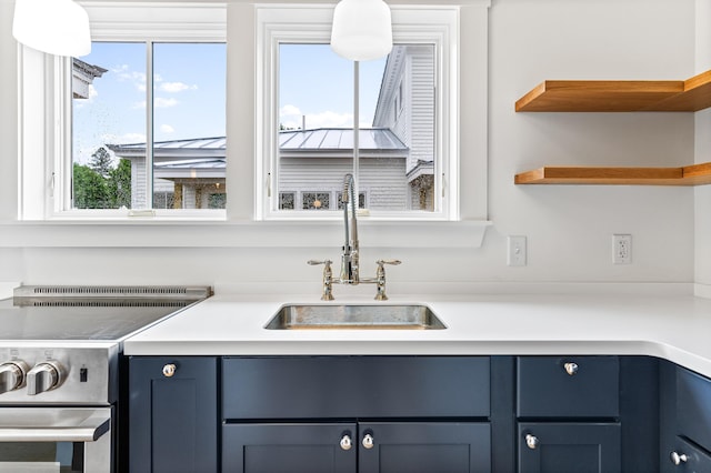 kitchen featuring blue cabinets, stainless steel electric range oven, and sink