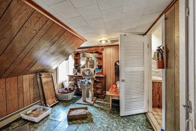 bonus room featuring baseboard heating, wood walls, and lofted ceiling