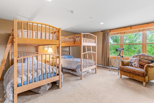 bedroom with carpet flooring and a baseboard heating unit