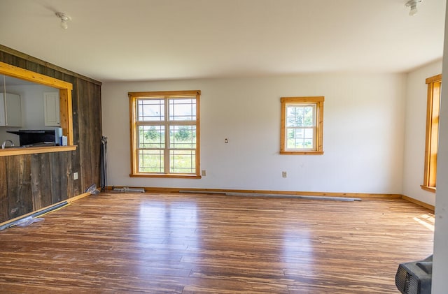 unfurnished living room with wooden walls and hardwood / wood-style flooring