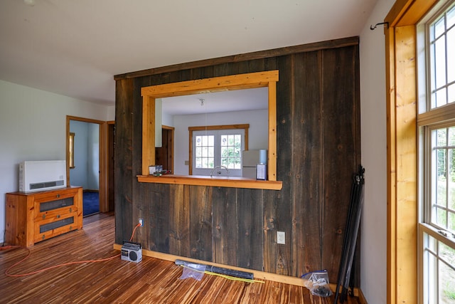 interior space featuring a wealth of natural light, sink, hardwood / wood-style floors, and wood walls