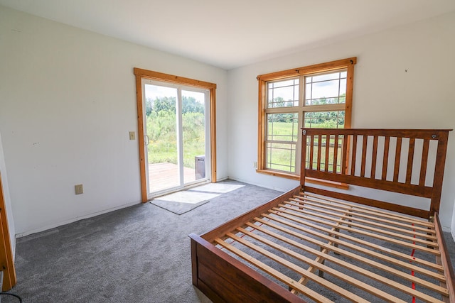 unfurnished bedroom featuring dark carpet and access to outside