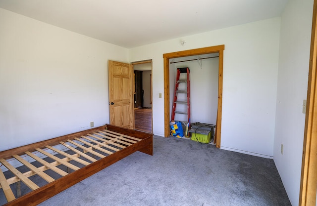 unfurnished bedroom with dark carpet and a closet