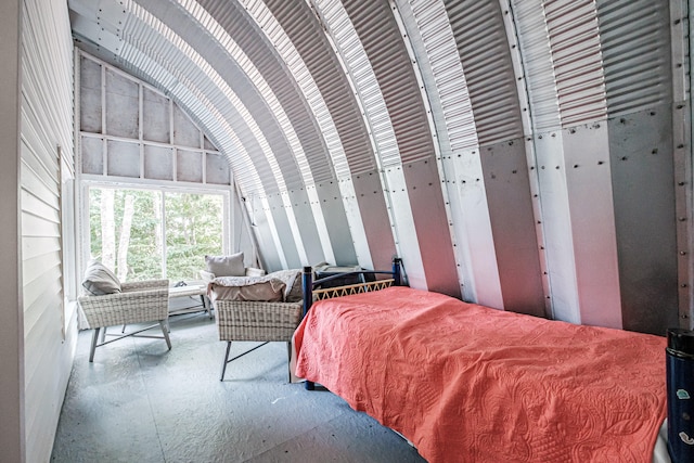 bedroom with vaulted ceiling and concrete floors