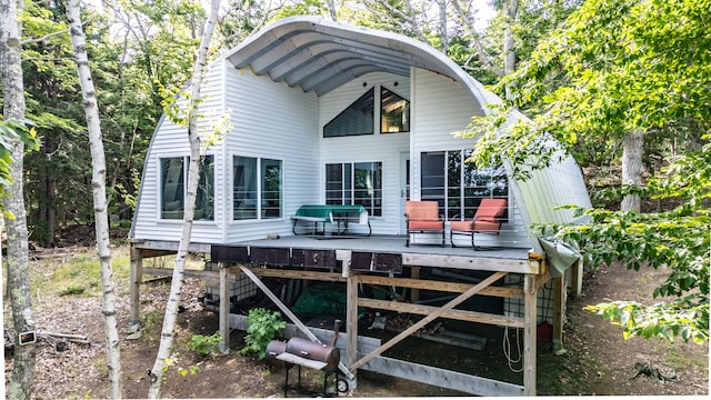 rear view of house featuring a wooden deck