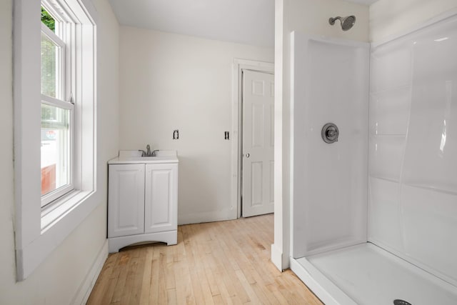 bathroom with hardwood / wood-style floors, a shower, and vanity