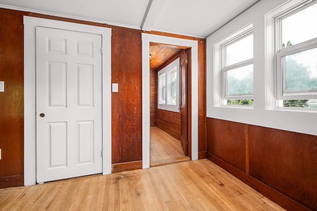 entryway with light wood-type flooring and wood walls