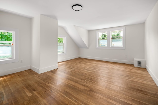 bonus room featuring vaulted ceiling, hardwood / wood-style flooring, and plenty of natural light