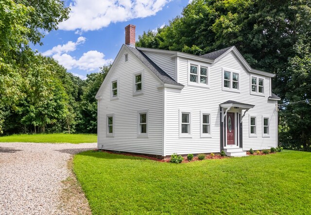 colonial inspired home featuring a front lawn