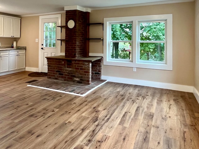 unfurnished living room with light hardwood / wood-style floors and crown molding