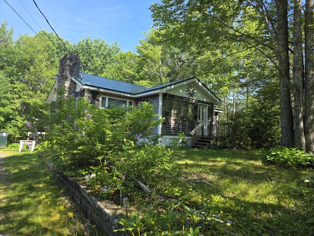 19 Resh Rd, Searsport, ME 04974 - view of side of property featuring a metal roof, a chimney, a deck, and a yard