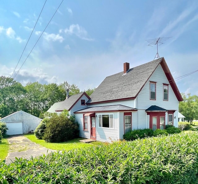 view of front of property with a garage and an outbuilding