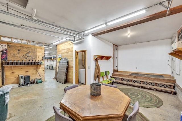 garage featuring washer / clothes dryer and wood walls