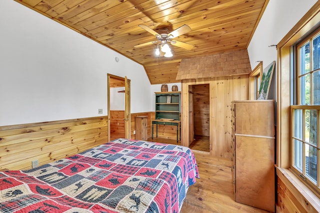 bedroom with wood walls, wooden ceiling, lofted ceiling, ceiling fan, and light wood-type flooring