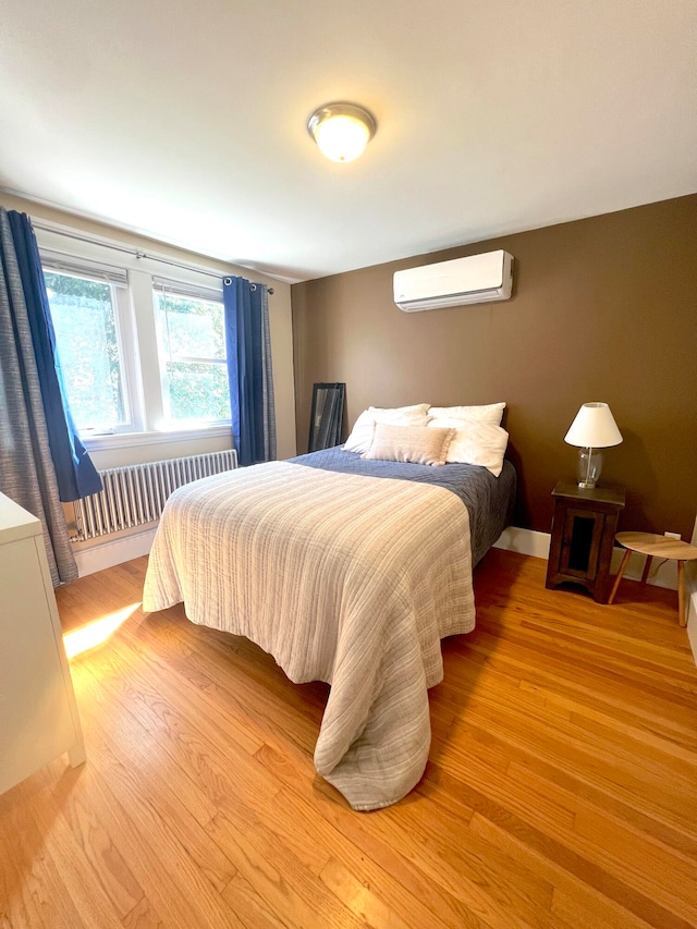 21 Dow St Unit 4, Portland, ME 04102 - bedroom with radiator, light wood finished floors, and a wall mounted AC
