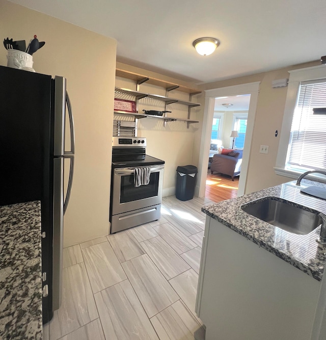21 Dow St Unit 4, Portland, ME 04102 - kitchen with stainless steel appliances, open shelves, stone countertops, and a sink
