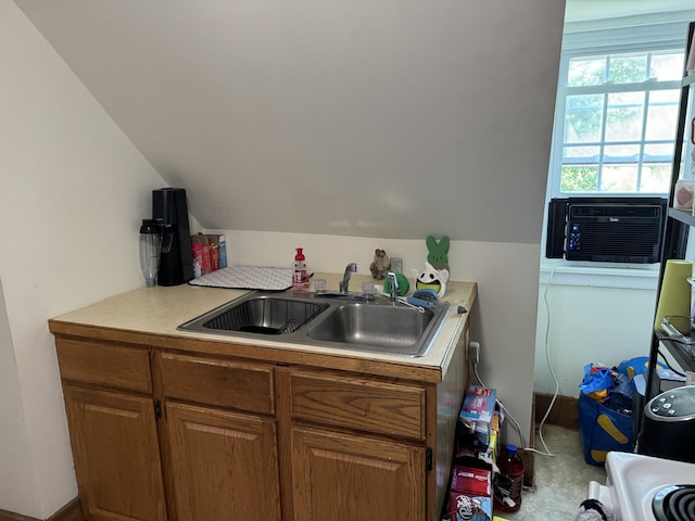 kitchen with vaulted ceiling, light countertops, a sink, cooling unit, and brown cabinets
