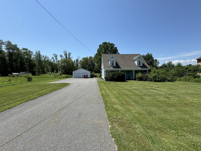 new england style home with a front lawn, a detached garage, and an outbuilding