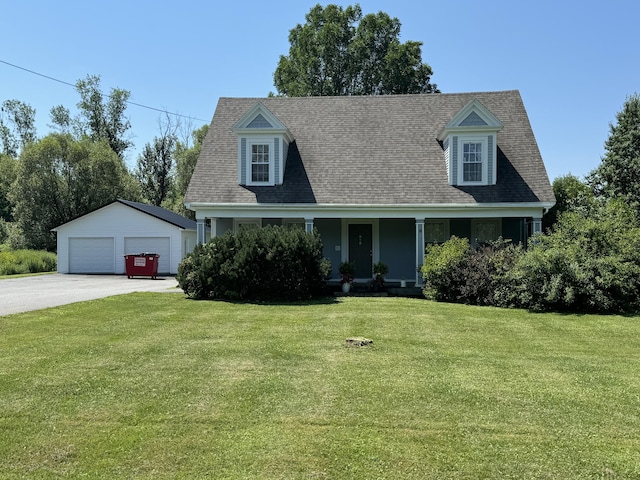 cape cod-style house featuring covered porch, a detached garage, a front yard, an outbuilding, and a shingled roof