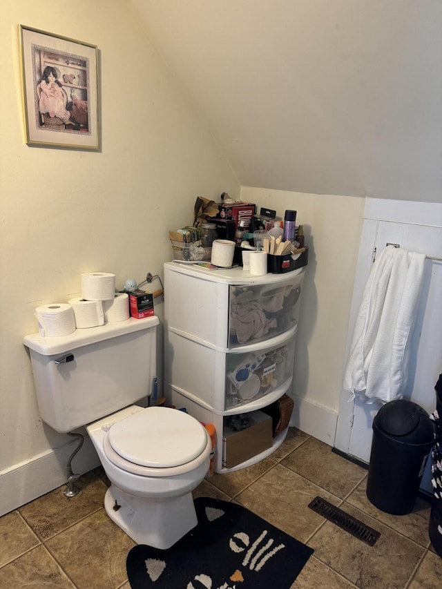 bathroom with toilet, baseboards, vaulted ceiling, and visible vents
