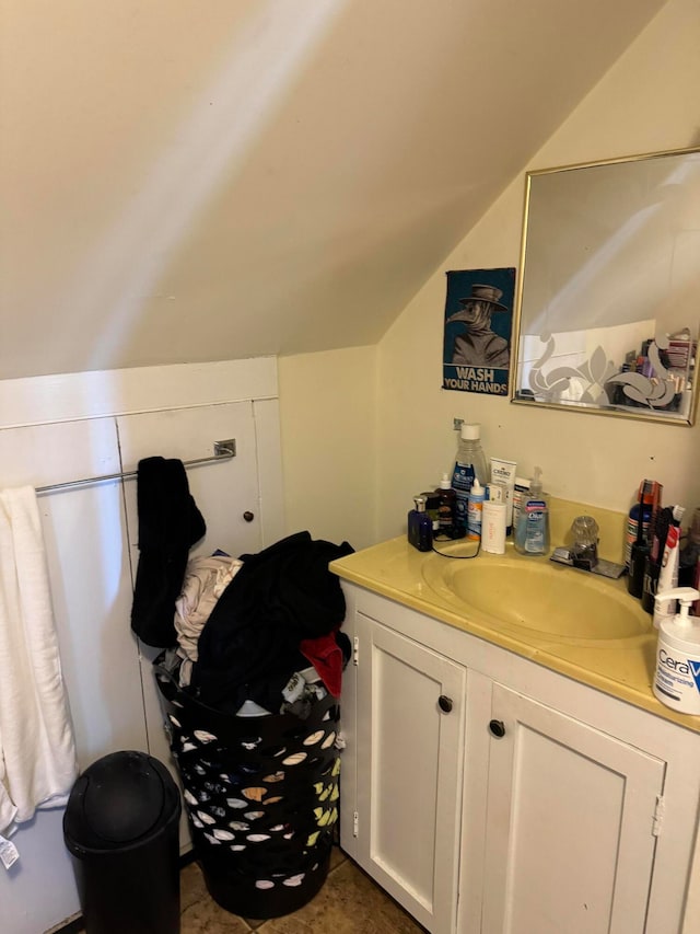 bathroom with vanity, tile patterned floors, and vaulted ceiling