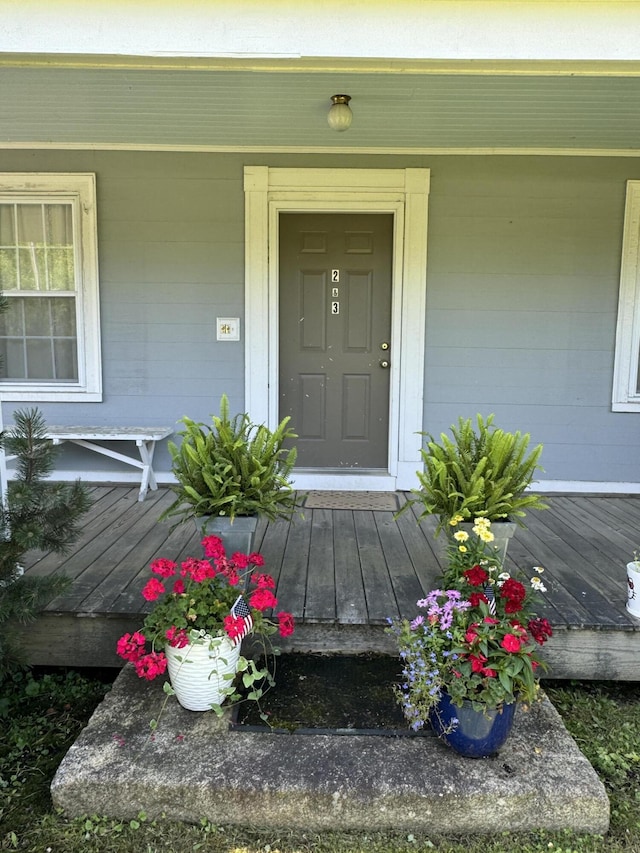 entrance to property with covered porch and concrete block siding