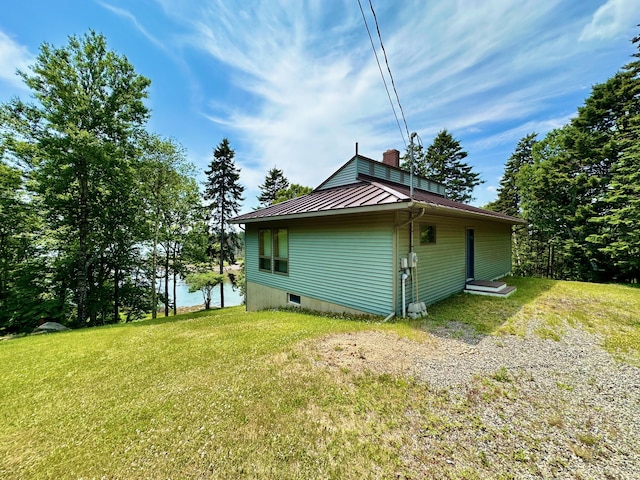54 Harbor Hills Ln, Addison, ME 04606 - view of side of property featuring a standing seam roof, a chimney, a lawn, and metal roof