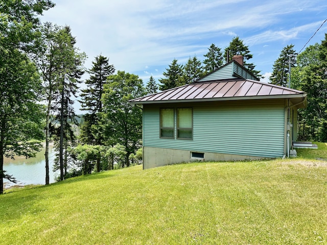 54 Harbor Hills Ln, Addison, ME 04606 - view of side of property with a standing seam roof, a lawn, a chimney, and metal roof