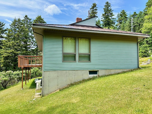 54 Harbor Hills Ln, Addison, ME 04606 - view of property exterior with a chimney, a yard, metal roof, a deck, and a standing seam roof