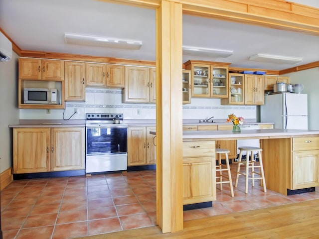 54 Harbor Hills Ln, Addison, ME 04606 - kitchen featuring electric range oven, freestanding refrigerator, stainless steel microwave, range hood, and tasteful backsplash