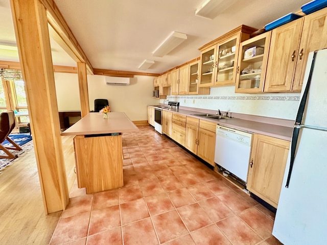54 Harbor Hills Ln, Addison, ME 04606 - kitchen with light brown cabinets, white appliances, an AC wall unit, a sink, and glass insert cabinets