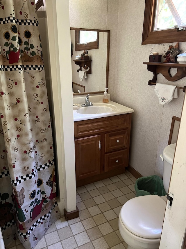 full bath featuring curtained shower, vanity, toilet, and baseboards