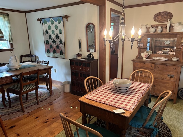 dining room with a notable chandelier, crown molding, and hardwood / wood-style flooring