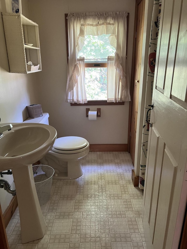 bathroom with toilet and baseboards