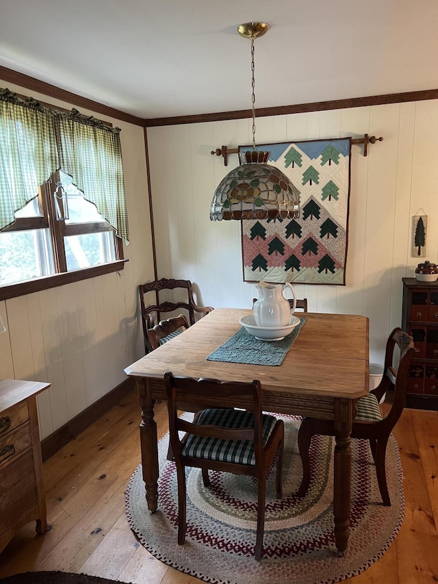 dining space featuring light wood-style flooring and crown molding