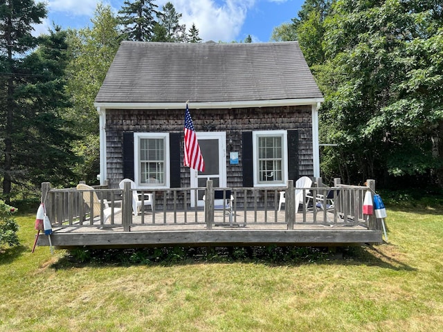 rear view of house featuring a deck and a lawn