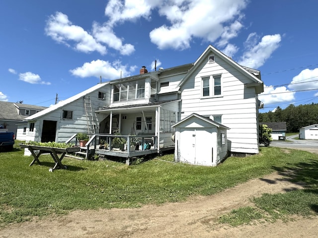 back of property featuring an outdoor structure, a storage unit, a yard, and a chimney