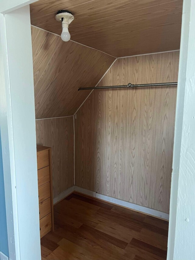 bonus room featuring vaulted ceiling, wooden ceiling, wood finished floors, wood walls, and baseboards