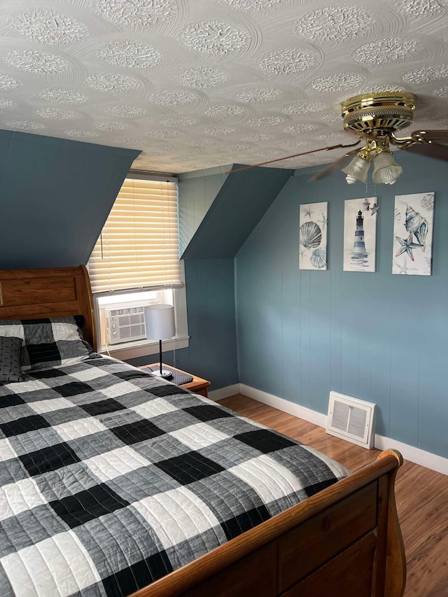 bedroom featuring a textured ceiling, hardwood / wood-style flooring, and cooling unit