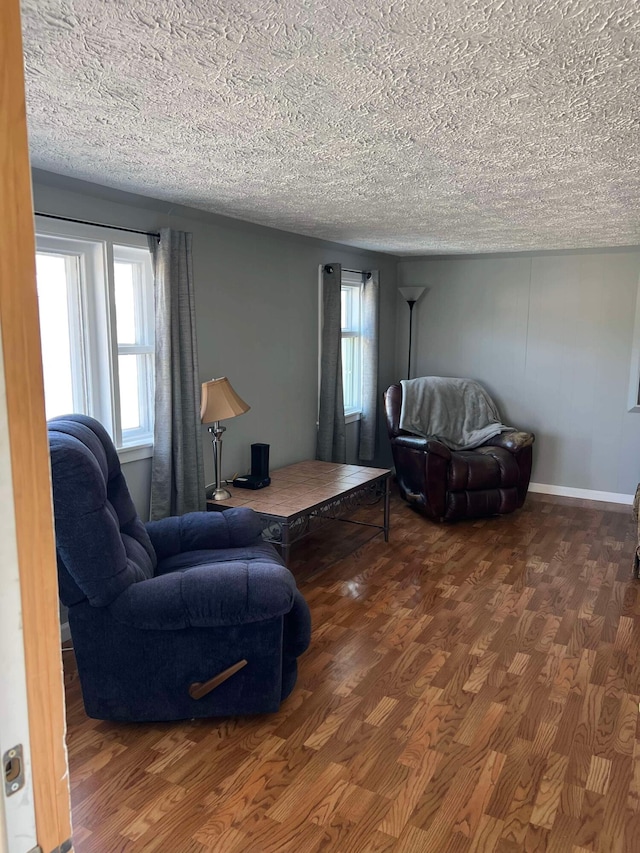 living room with a textured ceiling and dark wood-type flooring