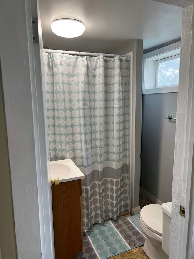 bathroom featuring toilet, vanity, baseboards, and a shower with shower curtain