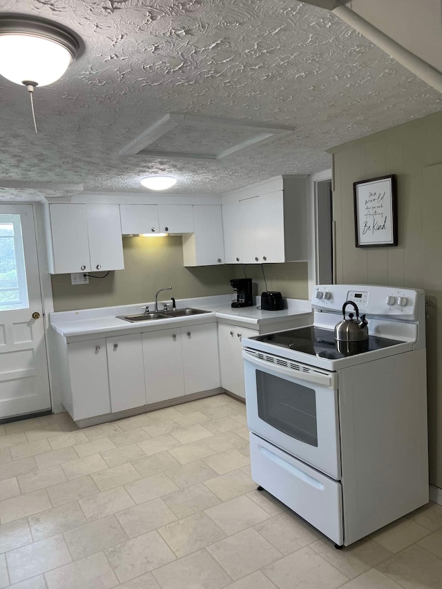 kitchen with a textured ceiling, white cabinetry, white range with electric stovetop, and sink