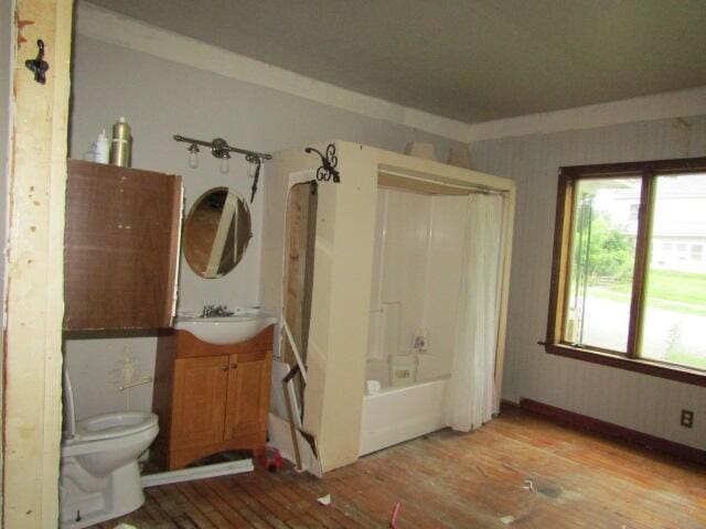 full bathroom featuring toilet, shower / tub combo, wood-type flooring, and vanity